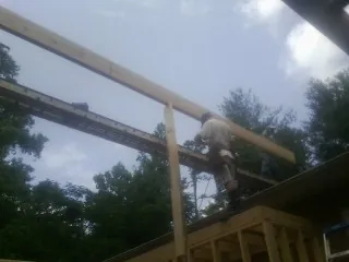 Carpenter setting a ridge beam over a new addition frame — Ice Dam Removal by Roofing Brothers in Sugar Grove